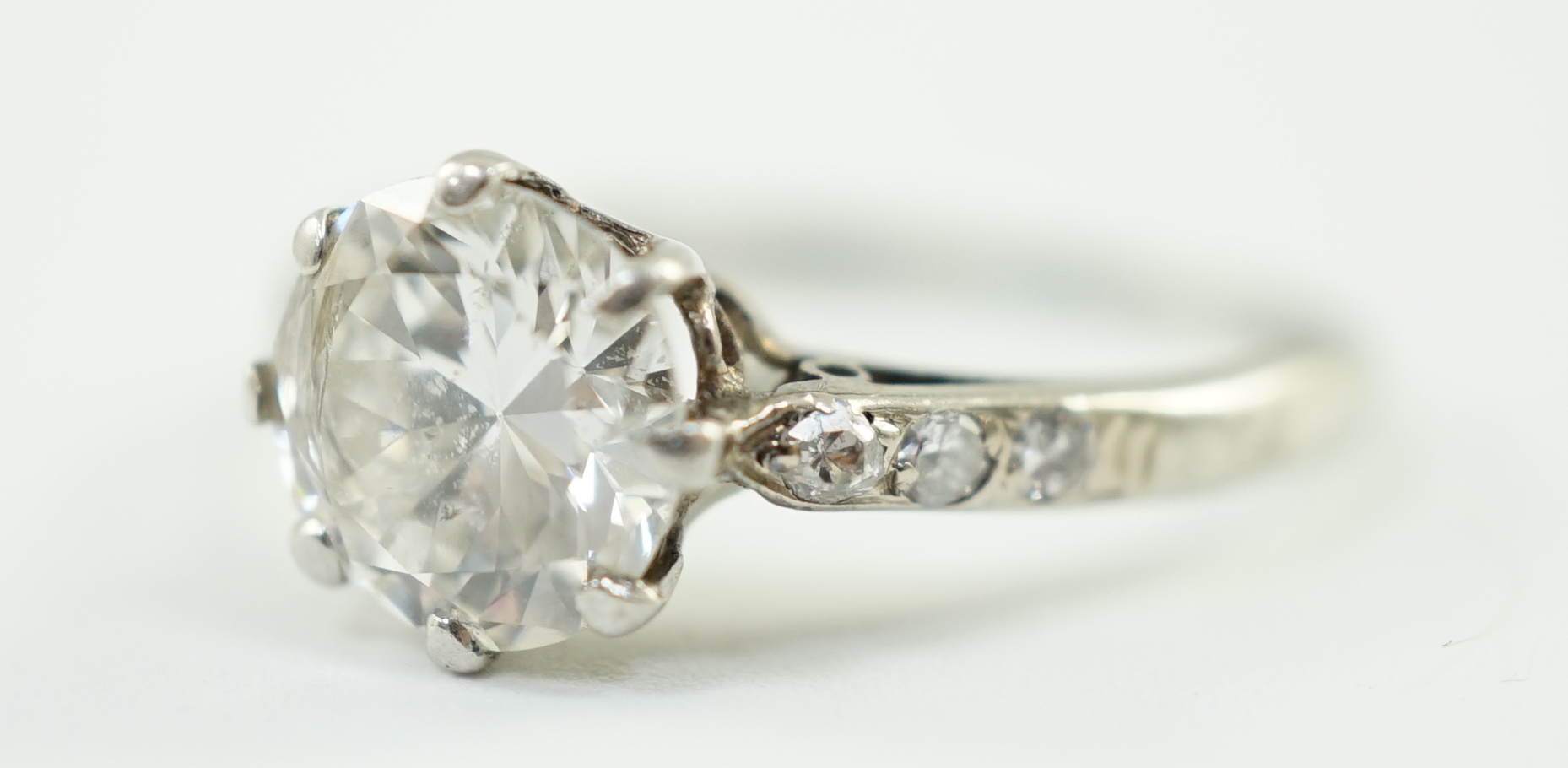 A platinum and single stone diamond ring, with diamond set shoulders